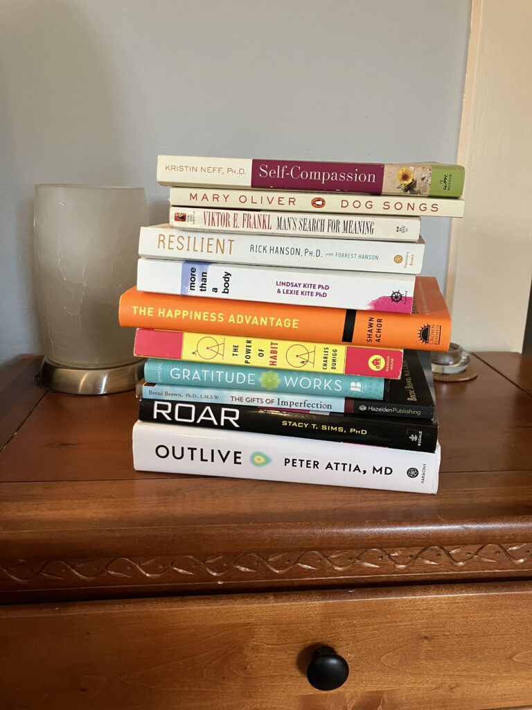 stack of inspirational books on a nightstand